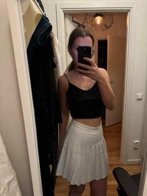 Vit plisserad tennisskjol med inbyggda shorts | Strl S - Snygg vit plisserad minikjol i klassisk tennisstil med inbyggda shorts under – praktiskt och bekvämt. Kjolen har en strukturerad midja och faller fint med de plisserade veckorna.  Storlek s.