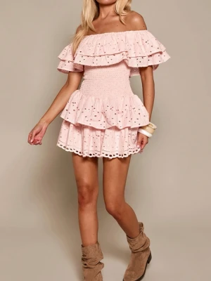 Ljusrosa offshoulder volangklänning - Söt ljusrosa kortklänning med offshoulder och volanger. Klänningen har broderade spetsdetaljer och smockad midja för en feminin siluett. Perfekt för sommarens varma dagar och har en luftig känsla. Storlek 34