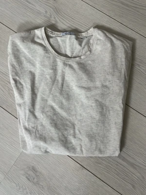 Ljusgrå basic t-shirt från Bläck - En enkel och stilren ljusgrå t-shirt från Bläck. T-shirten har rund halsringning och är tillverkad i mjukt bomullsmaterial. Perfekt för en clean och avslappnad look.