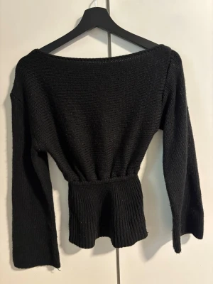 Svart stickad tröja från SHEIN - Svart stickad tröja från SHEIN med bred resår i midjan som ger en snygg siluett. Tröjan har långa ärmar och en något vidare halsringning. Perfekt för dig som gillar en enkel men trendig look.