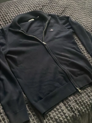 GANT cardigan mörkblå - GANT cardigan / ziptröja, 100 % bomull, storlek 164 (13–14 år). Mycket fint skick, inga hål, fläckar eller slitage.