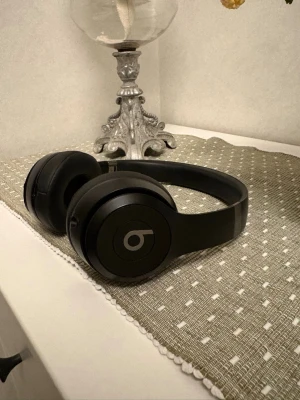 Svarta Beats Solo3  - Stilrena svarta on-ear hörlurar från Beats, modell Solo3. Trådlös design med vadderade öronkuddar och justerbart huvudband. Köptes i somras på arlanda. Orginalbox med sladd medföljer. Nypris 2695kr.