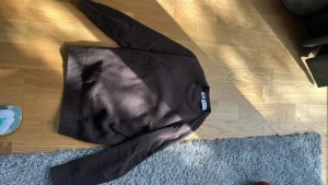 Brun stickad tröja - Mysig brun stickad tröja med rund hals och ribbade muddar vid ärmslut och nederkant. Tröjan har en diskret struktur i materialet och en avslappnad passform som passar perfekt till jeans. Från märket selected 