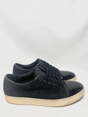 Lanvin Cap Toe Sneakers - Lanvins i en populär model med glansig framtå! Okej skick men de har mycket kvar att ge! 6,5/10, mockan är sliten och finns märken på framtån, men inget som märks speciellt mycket vid använding. Uk 12 passar 46. Kontakta mig för fler frågor och funderingar!
