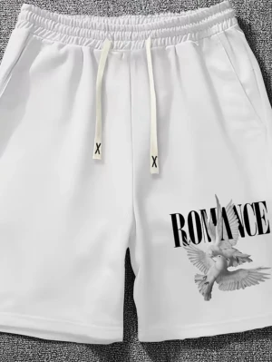 Vita shorts med tryck och snörning - Snygga vita shorts med elastisk midja och snörning. På ena benet finns ett tryck med texten 'ROMANCE' och en duva. Shortsen har sidofickor och är tillverkade i mjukt material som passar perfekt till sommaren.