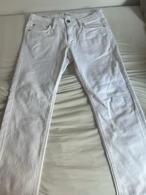 Vita slim fit jeans från Jack & Jones - Snygga vita slim fit jeans från Jack & Jones med klassisk femficksmodell och silverfärgade nitar. Jeansen har normal midja och raka ben. Tillverkade i mjuk bomullsdenim som ger en clean och fräsch look. storlek 30 30