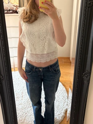 Vit spetsblus med volangdetaljer - Säljer min superfin vita topp i spets med vackra volangdetaljer vid ärmar och nederkant. Toppen är från only i storlek xs💗