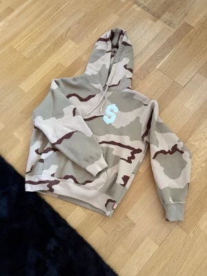 Supreme Hoodie Military Kahki Print - Sparsamt använd Supreme hoodie inköpt tidigt 2024. Size S fits M. Condition 9/10. Kvitto kan uppvisas.