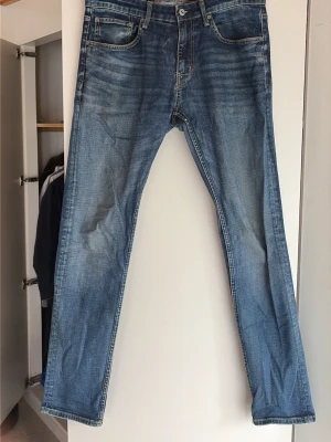 Blå vintige jeans från crocker  - Säljer ett par klassiska blå jeans från crocker med raka ben och snygg slitning framtill. Jeansen har fem fickor, normal midja och är gjorda i mjuk denim. Perfekta för en avslappnad och trendig look.
