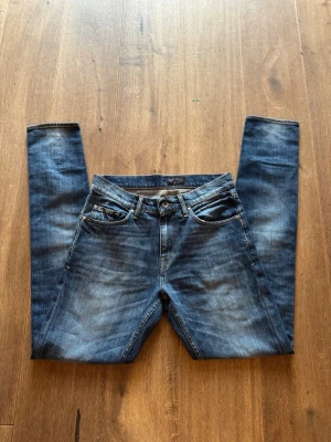 Tiger of Sweden jeans - Snygga blå slim fit jeans med lätt slitna detaljer och klassisk femficksdesign. Jeansen har normal midja och raka ben. Perfekta för en avslappnad och trendig look. Materialet är denim i bomull med lite stretch för extra komfort.