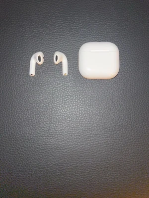 Airpods 4 ANC - Säljer ett par vita Apple AirPods med tillhörande laddningsetui. Trådlösa hörlurar med stilren och kompakt design i blank plast. Perfekta för musik, samtal och träning. Laddningsetuiet har LED-indikator på framsidan.