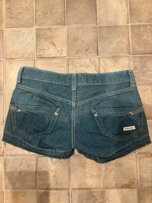 Super lågmidjade shorts i snygg speciell gråblå färg  - Super låga, lågmidjade shorts knappt använda väldigt fint skick. Speciell snygg färg med knapp och dragkedja. Midjemått ca 34,5cm