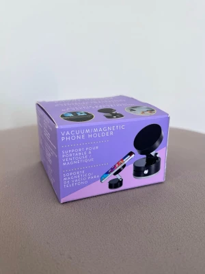 Magnetisk mobilhållare med vakuum (ny) - En magnetisk mobilhållare som fästes med sugpropp (vakuum). Kan användas på vilken yta som helst, fönster, vägg, bord osv. Perfekt för att filma eller ta kort.  Fungerar med magnetplatta eller magsafe.  Endast öppnad och testad.