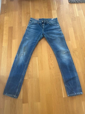 Blå raka jeans med slitningar - Säljer ett par blå dondup med snygga slitningar på både fram- och baksida. 