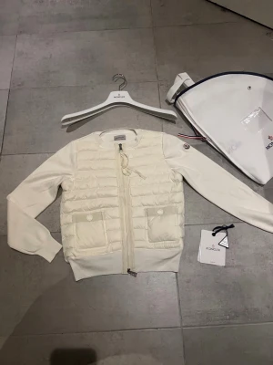 Moncler cardigan  - Hej! Jag säljer nu min jättefina Moncler cardigan. Cardiganen är i jättebra skick och har inga defekter eller liknande skicket 9,5/10. Den är äkta och köpt online. Jag säljer den pågrund av att den inte riktigt passar min personliga stil. Moncler dustbag lapprna osv ingår med jackan. Hör av dig vid minsta lilla fråga! 💕