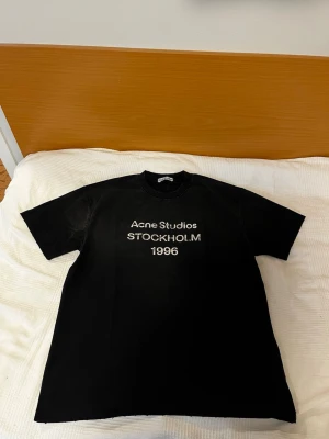 Svart Acne Studios t-shirt - Iprincip oanvänd, som helt ny, 58 cm bredd, 72cm höjd. Kom med bud och frågor! 