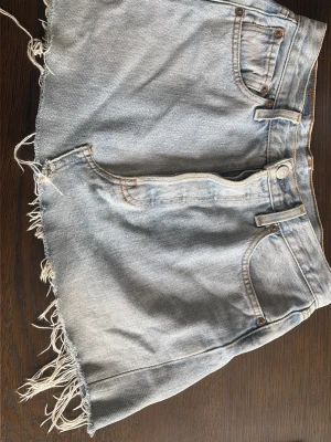 Ljusa jeansshorts från Levi's - Säljer en jättefin ljusblå jeanskjol från Levi’s 