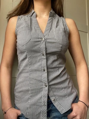  ärmlös blus skjorta - Grå vid randig ärmlös skjorta. Lite silver i de vita ränderna men det syns inte. Erbjuder rabatt vid köp av flera plagg ✨✨✨
