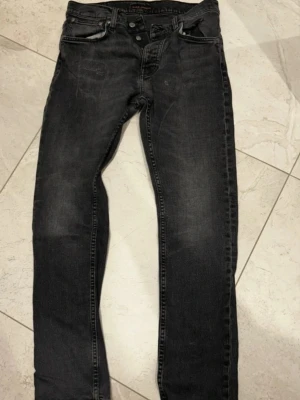  Nudie Jeans - Säljer ett par svarta jeans från Nudie Jeans med klassisk femficksmodell och snygga slitningar. Jeansen har en diskret tvättad look och Nudie-loggan på bakfickan. Perfekta för dig som gillar en smal passform pris kan diskuteras😁