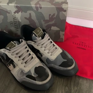 Valentino Rockrunners Vit-Camo - Säljer nu dessa tvärsnygga rockrunners då dom är för små. Storlek 43 men passar bra på 44 också. Bra skick, har använts några gånger men har tagits väl hand om. Skokartong och dustbag ingår!🤩🔥