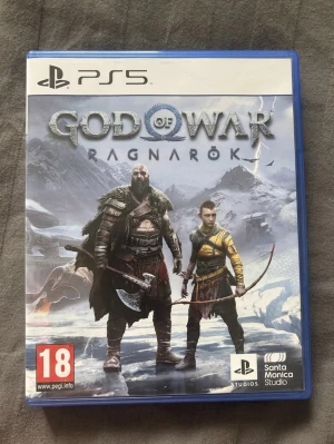 God of War Ragnarök PS5 spel - Säljer God of War Ragnarök till PlayStation 5. Spelet kommer i ett blått plastfodral med snyggt omslag där Kratos och Atreus syns mot en snöig bakgrund. Perfekt för dig som gillar actionfyllda äventyr och nordisk mytologi.