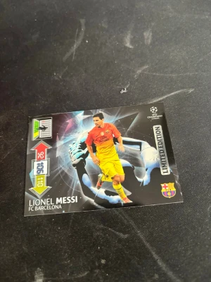 Panini Champions League Messi-kort - Limited Edition samlarkort från Panini Adrenalyn XL 2012-2013 med Lionel Messi i FC Barcelona. Kortet har färgstark design med Messi i gul och röd matchdräkt, Champions League-logga och statistik. Perfekt för samlare av fotbollskort.