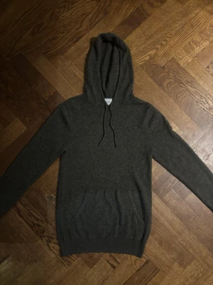 Mörkgrön Kashmir hoodie John Henric Small - Mjuk och lyxig mörkgrå hoodie från John Henric i 100% cashmere. Klassisk modell med huva. Perfekt för dig som vill ha en stilren och bekväm hoodie med exklusiv känsla.