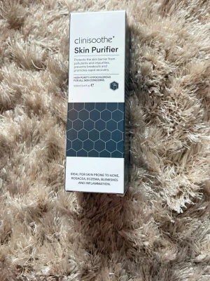 Clinisoothe+ Skin Purifier Face Mist - Clinisoothe+ Skin Purifier är en ansiktsmist i vit och grå förpackning med hexagonmönster. Den innehåller hypoklorsyra och passar alla hudtyper, även känslig hud. Fri från alkohol, sulfater och parfym. Perfekt för dig med akne, rodnad eller eksem.