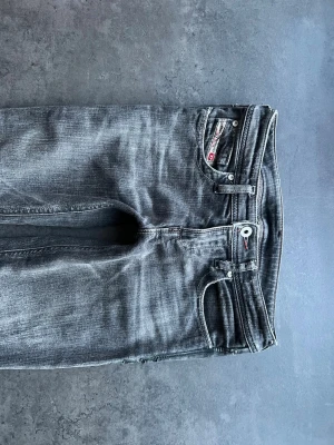 Gråa jeans från Diesel - Snygga gråa jeans från Diesel med klassisk femficksmodell. Jeansen är raka/bootcut med låg midja. Midjemåttet är ca 35cm och innerbenslängden ca 80