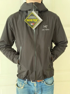 (Helt ny)Svart vindjacka från Arc'teryx  - ( KÖPT PÅ VINTED!!) ( MODDELEN ÄR 185 OCH VÄGER 75kg)Snygg svart vindjacka från Arc'teryx. Jackan har huva, hel dragkedja framtill och två snedställda fickor med dragkedja. Perfekt för dig som vill ha en lätt och funktionell jacka.