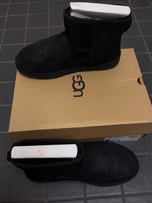 Säljer ett par UGG Classic Mini II Black – Size 42 EU - Skorna är i mycket bra skick och använda en säsong. Normalt slitage förekommer men inget som påverkar användningen eller syns.  Klassiska och väldigt bekväma boots med mjukt foder som håller fötterna varma. Originalkartong medföljer.  Size: 42 EU 🏷️ Rabatt vid köp av flera par skor!