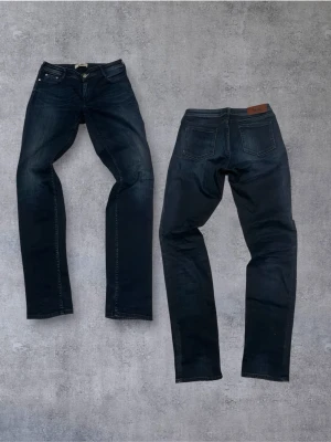 Mörkblå Acne studios jeans - Snygga mörkblå jeans från A.P.C. med raka ben och klassisk femficksmodell. Jeansen har subtila slitningar framtill och kontrastsömmar. Tillverkade i kraftig denim med en tidlös look och läderpatch bak i midjan.