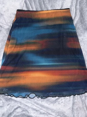 Flerfärgad meshkjol med vågigt mönster - snygg kjol med vågigt mönster ned till