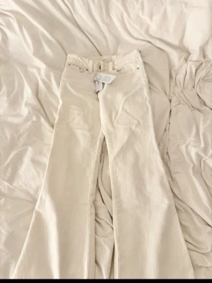 vita lågmidjade bootcut jeans från gina tricot  - säljer ett par vita lågmidjade bootcut jeans från gina tricot. storlek 32 men hade passat en 34! har använt byxorna 1 gång så lapparna är inte kvar som på bilden!