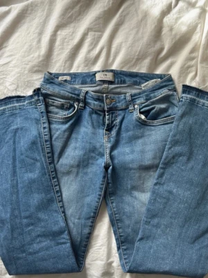 Ljusblå bootcut jeans från LTB - Säljer ett par ljusblå jeans från LTB med bootcut passform och klassisk femficksdesign. Jeansen har normal midja, bälteshällor och stängs med dragkedja och knapp. Perfekta till en avslappnad stil. Sprättat upp längst ner. 