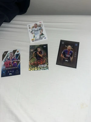 Samling fotbollskort Topps Champions League - Fyra olika fotbollskort från Topps Champions League-serie. Korten har färgstarka och glansiga designer med spelare i matchställ från olika europeiska klubbar. Perfekt för dig som gillar att samla på sportkort eller vill byta med vänner.