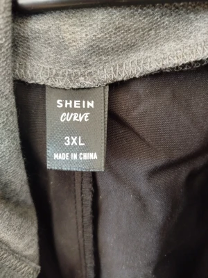 Svart vindjacka med grå huva SHEIN - Snygg svart vindjacka från SHEIN Curve i storlek 3XL. Jackan har en grå huva med dragsko och dragkedja framtill. Lätt material som passar perfekt för blåsiga dagar. Praktiska fickor på sidorna och avslappnad passform.200kr