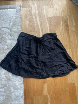 Svart satinkjol - Säljer en svart kjol, har några ”revor” i materialet, som på sista bilden! 