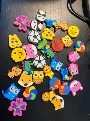 Färgglada suddgummin med djurmotiv sudd barn  - Samling med färgglada suddgummin i olika former som ugglor, lejon, kaniner, katter, fjärilar, fotbollar och basketbollar. Perfekta till skolan eller som roliga små presenter. Materialet är mjukt gummi och motiven är detaljerade och lekfulla.