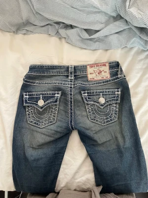 True Religion jeans - Säljer ett par blå jeans från True Religion. De är bootcut med en tvättad look. Köpta i usa så därför är de sällsynta (aldrig sett någon annan stans) säljer pga av för små. Pris kan diskuteras!