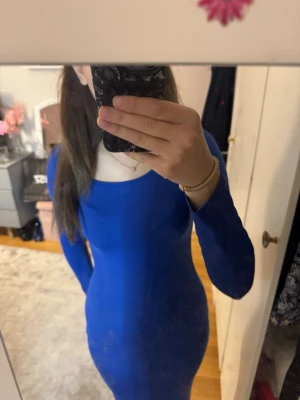  blå långärmad klänning - Passar även xs Snygg blå klänning med lång ärm och rundad halsringning. Modellen är kroppsnära och har en stilren, enkel design som framhäver figuren. Perfekt för dig som gillar en minimalistisk look.