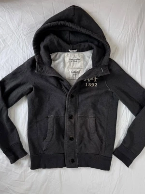 Mörkgrå kofta från Abercrombie & Fitch - Säljer nu en Abercrombie and Fitch Kofta👕                                                              Storlek: L, Skick: 9/10, Skriv vid minsta fråga, Fraktar alltid inom 24h efter köp📦