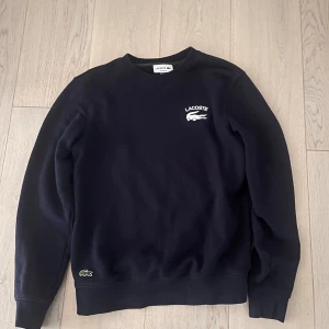 Mörkblå sweatshirt från Lacoste XS - Säljer en mörkblå sweatshirt från Lacoste i klassisk passform. Den är väl andvänd och inga defekter på den. Säljer den för att det inte passar längre. Ny pris är runt 1200 och jag säljer den för 549!
