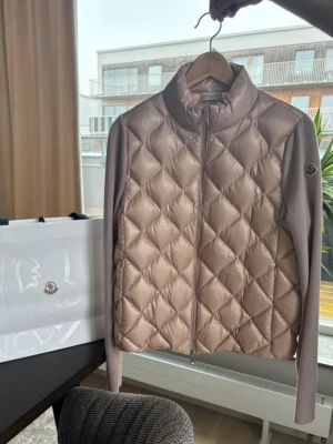 Rosa dunväst från Moncler - Quiltad skaljacka storlek S Detaljer - ljusrosa - dragkedja fram - två passpoalfickor i sidan Material Foder: polyamid 100%,  gåsdun 90%,  fjädrar 10% Yttre: polyamid 100%,  jungfruull 100%  Nypris just nu: 11 700 på Monclers sida!   Köpt i monclers butik i Oslo! Bild på kvitto finns på sista sliden.  Jackan ser grå ut på vissa bilder men är LJUSROSA i verkligheten, se alla bilder för bättre färg på jackan! Bilderna visar en logga man får med cardiganen!💞💞