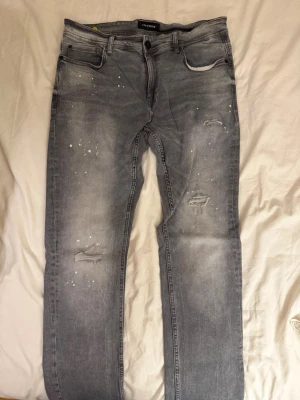 Grå slitna jeans från SNOG DENIM - Säljer ett par grå jeans från SNOG DENIM i storlek 32/34. 