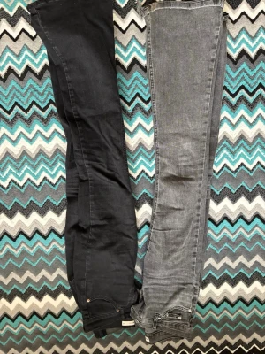 Svarta och gråa lågmidjade jeans från Gina  - Lågmidjade jeans från Gina. Den gråa i storlek 32 och den svarta i 34. Dom är jätte fina och sitter fint. Man kan köpa en för 250 och 2 för 400