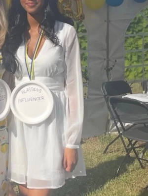 Vit somrig studentklänning  - Säljer min fina studentklänning! Använd endast en gång och det var på studenten 2024. Älskade denna och satt på plats hela dagen! Den har inte kommit till användning efter studenten och därför säljer jag den.