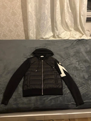 Moncler Cardigen - Säljer en Moncler cardigan i helt nytt skick. Den är tyvärr för liten för mig, därför säljer jag den vidare. Använd endast ett fåtal gånger och är mycket välskött utan skador eller slitage.