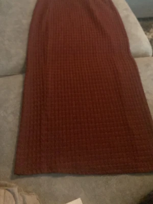 Brun långkjol i ribbad manchester - Snygg vin röd  långkjol i ribbad manchester med klassisk rak passform. Kjolen har en enkel och stilren look som passar perfekt till olika outfits. Perfekt för dig som gillar en tidlös och trendig stil.