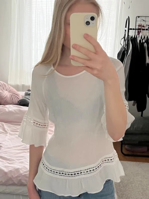 Vit blus med volang från Esprit - Säljer denna söta vita blus från Esprit med volangdetaljer och inslag av spets. Perfekt nu till våren och sommaren!